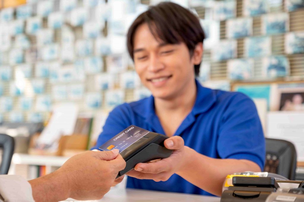 Основна увага на кредитній картці азіатського працівника або персоналу на стійці реєстрації отримують оплату кредитною карткою від старшого чоловіка. Концепція гарного обслуговування для бізнес-системи підтримки клієнтів.